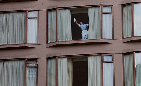 Captan momento exacto en que mujer realiza maniobra extrema para limpiar sus ventanales