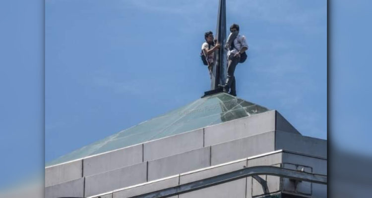 Dos secundarios suben a la cúspide del edificio de Caja Los Andes en Concepción