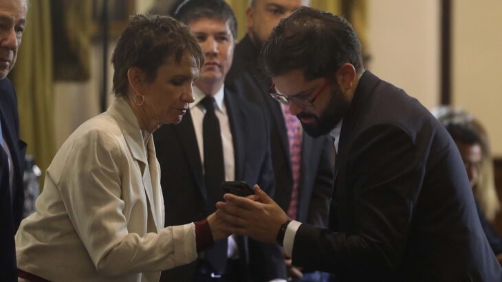 Carolina Tohá le muestra su teléfono al presidente Gabriel Boric