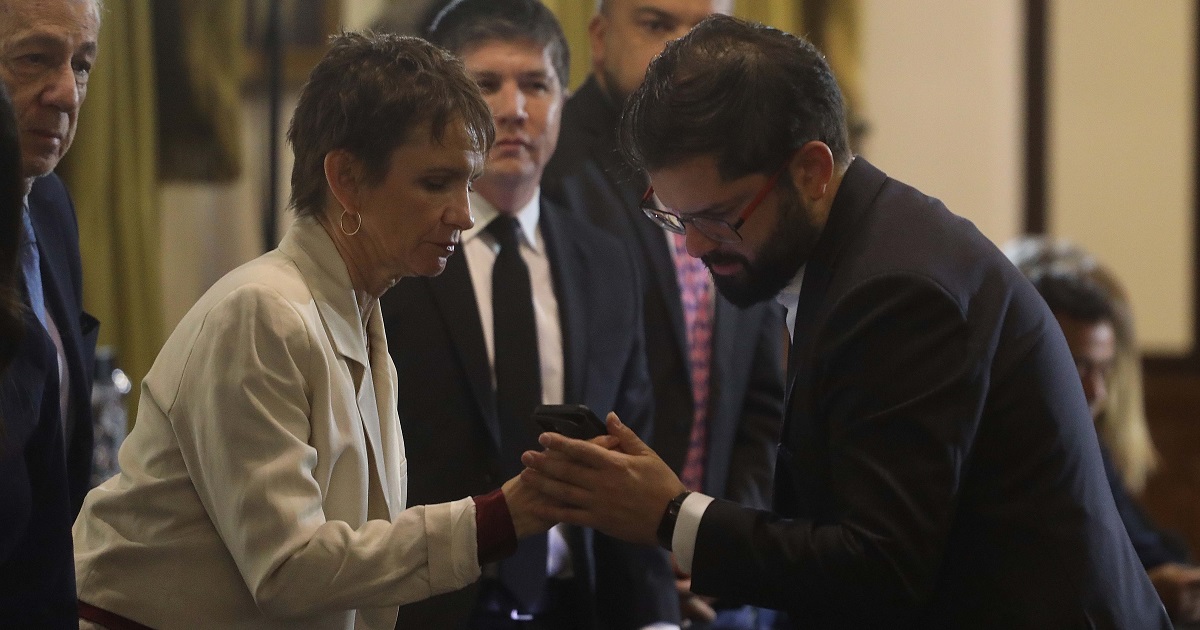 Carolina Tohá le muestra su teléfono al presidente Gabriel Boric